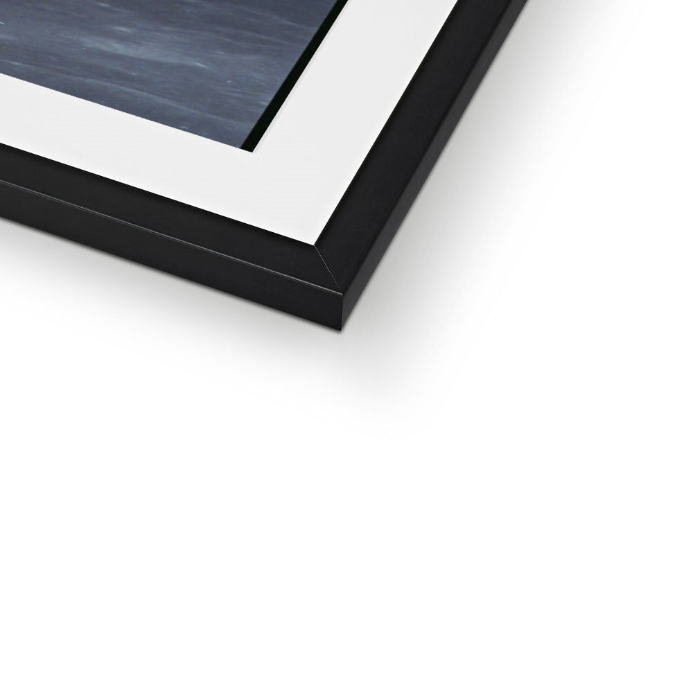 Close-up of the bottom corner of an Earthrise framed print showing the black frame and white mount