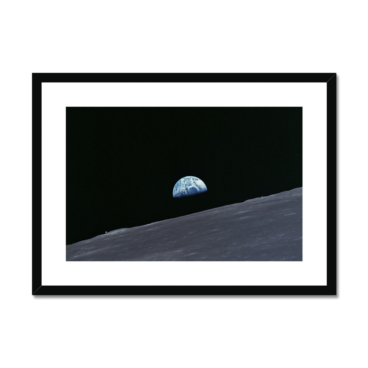Earthrise framed and mounted print showing Earth rising over the Moon's horizon in a black frame, landscape front view