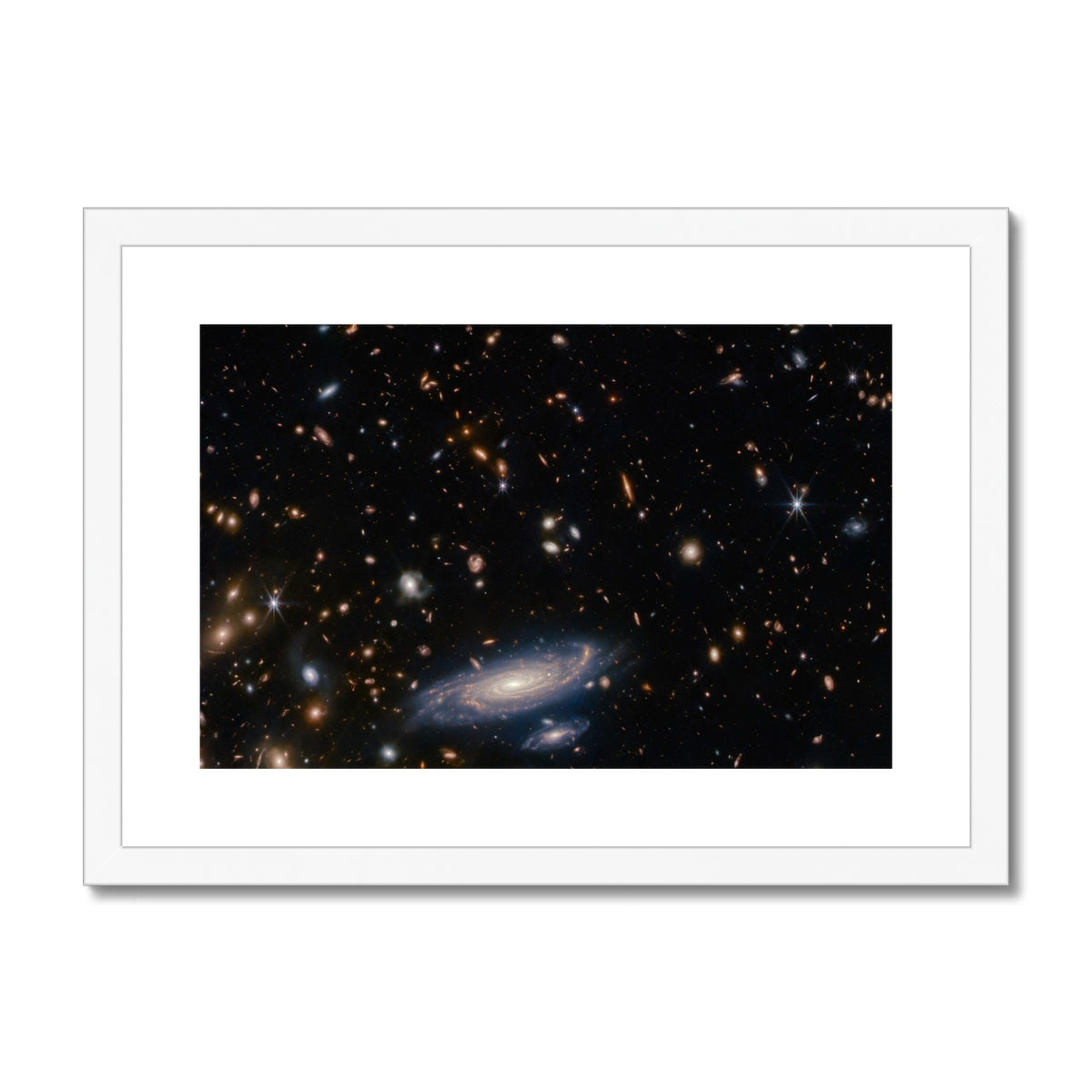 Spiral Amongst Thousands framed and mounted print showing a spiral galaxy among distant galaxies in a white frame, front view