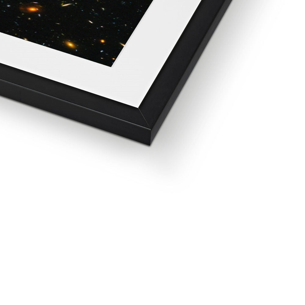 Close-up of the bottom corner of a JWST Deep Field framed print showing the black frame and white mount